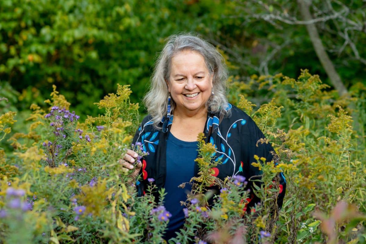 Robin Wall Kimmerer standing in wildflowers
