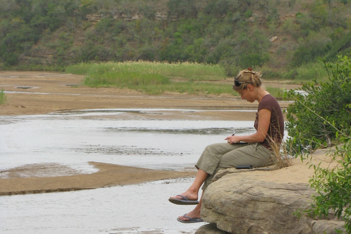 Woman taking notes overlooking wetlands. Photo credit: Wilderness Leadership School