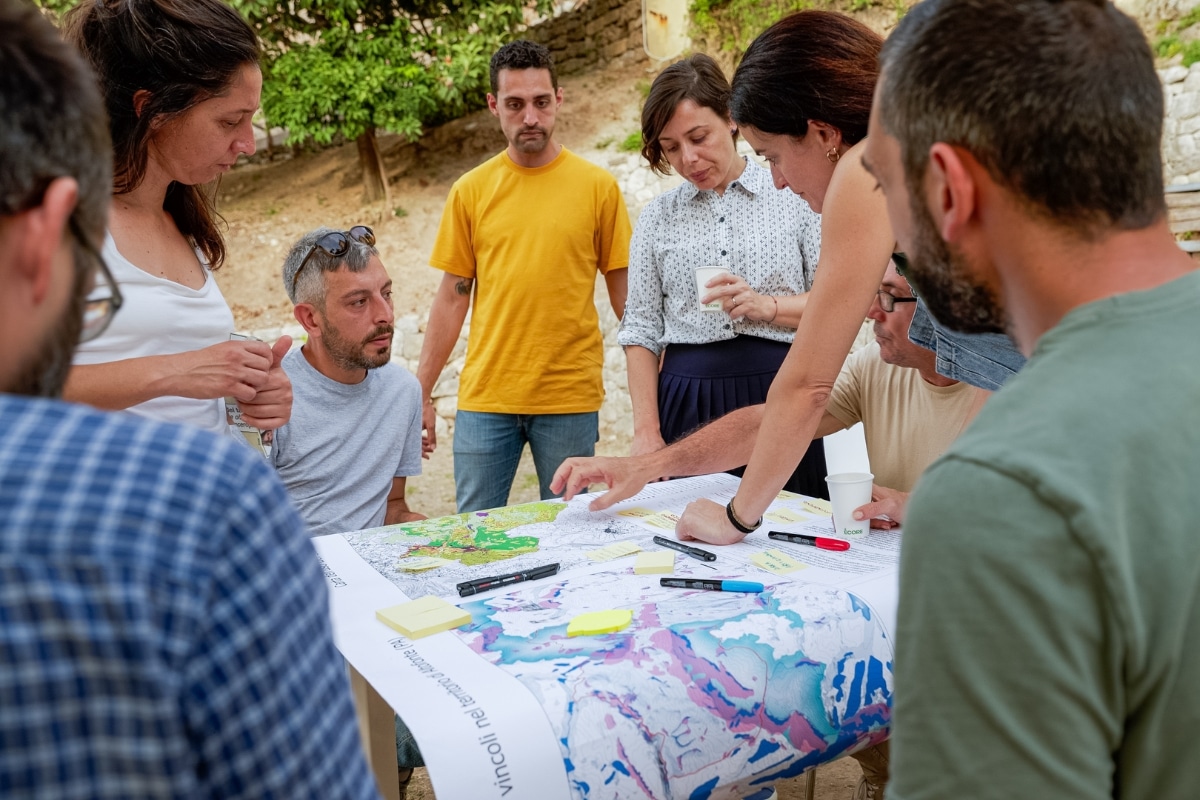 People gathered around a map Collettivo Rewild Sicily