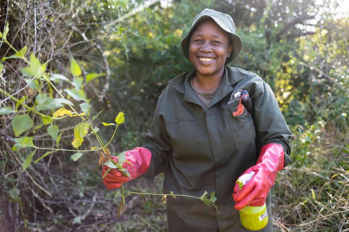 Green Mamba Lady holding spray and working on vegetation