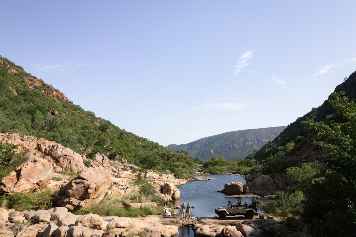 A safari group relaxing by a lake
