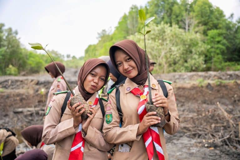Women holding mangrove saplings