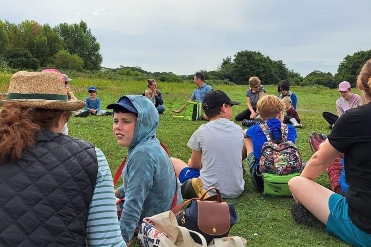 community gathering on the grass with peoples park for nature